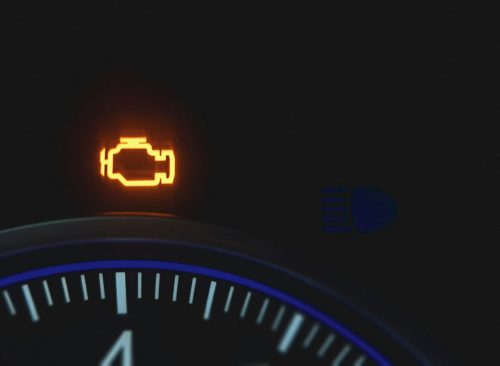 Illuminated amber check engine warning symbol on a dashboard