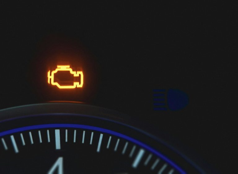 Illuminated amber check engine warning symbol on a dashboard