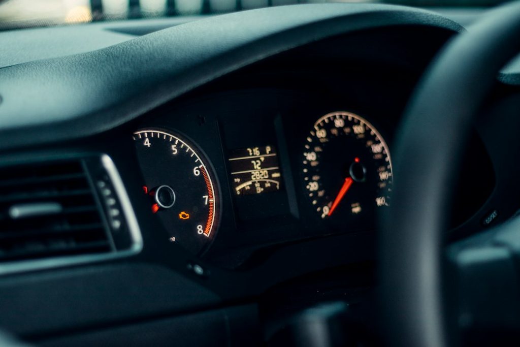 Vehicle instrument cluster displaying an engine warning light